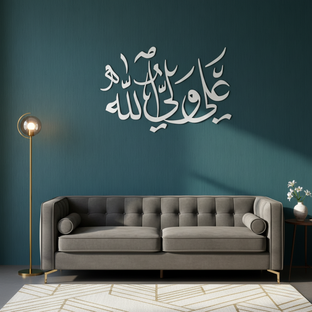 ArcDew Ali Waliyullah Decor Acrylic Islamic Art Muharram UAE - arcdew.com - Silver ArcDew branded acrylic Islamic calligraphy wall art above gray sofa.