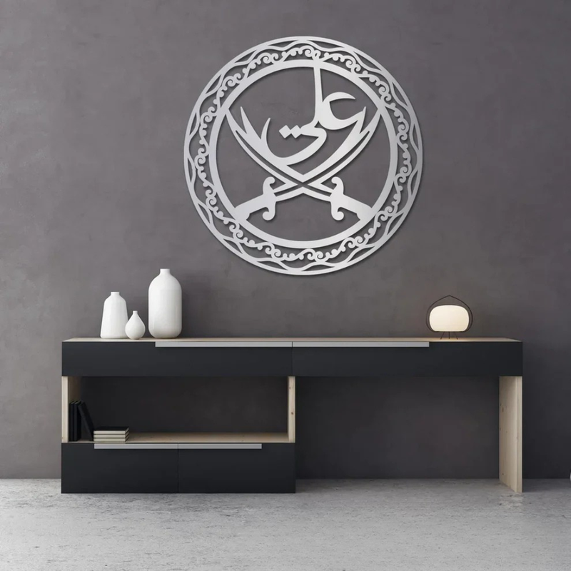 Arcdew Ali Sword Islamic Calligraphy Wall Art | Moharram Acrylic Wall Decor - arcdew.com - Silver acrylic Arcdew Ali Sword Islamic calligraphy wall art with intricate circular design on gray wall.