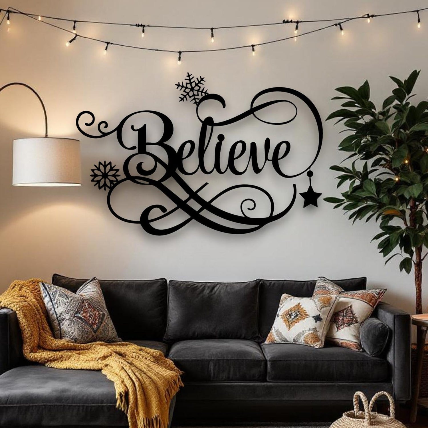 Living room with a black 'Believe' wall decoration above a gray sofa.