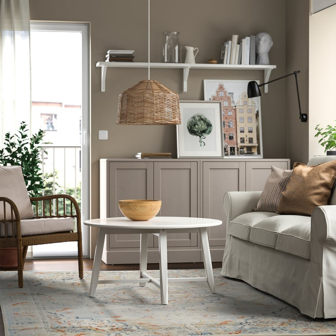 Living room with beige sofa, wooden armchair, and white coffee table.
