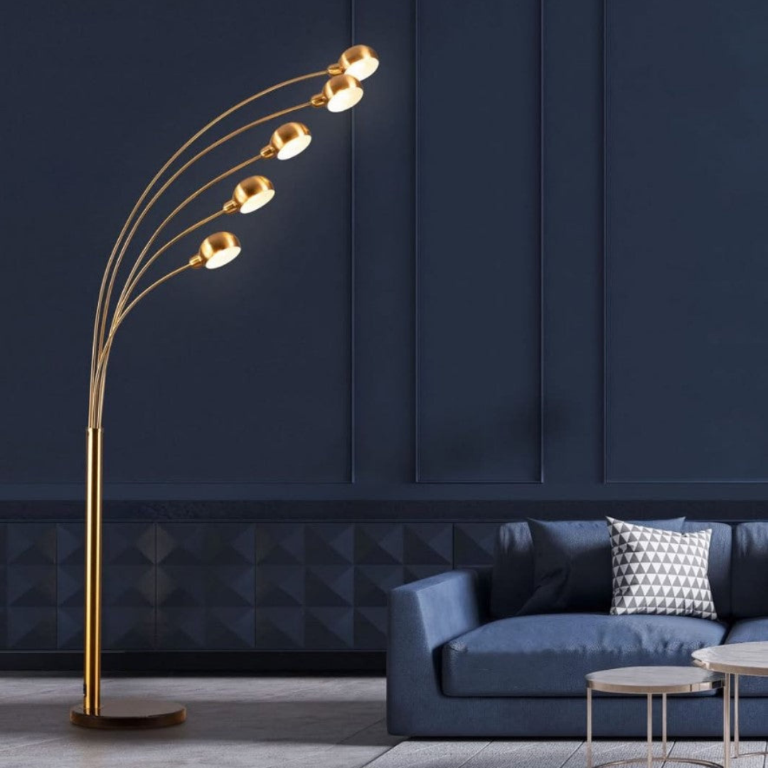Gold floor lamp with multiple lights in a modern living room setting.