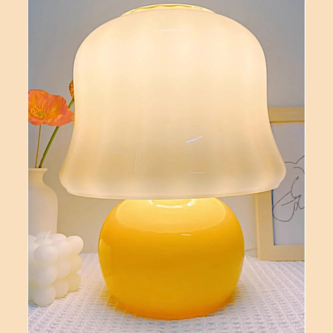 Yellow table lamp with a white shade on a textured surface, with a blurred background.