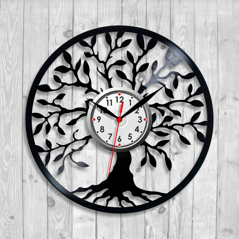 Decorative wall clock with tree design on a wooden background