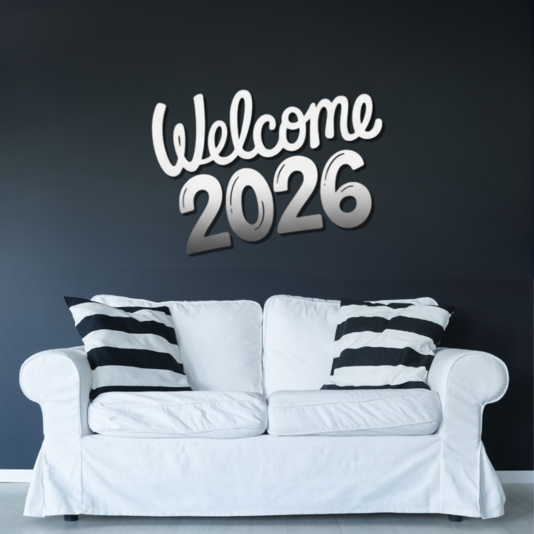 White sofa with black and white striped pillows against a dark wall with 'Welcome 2026' text.