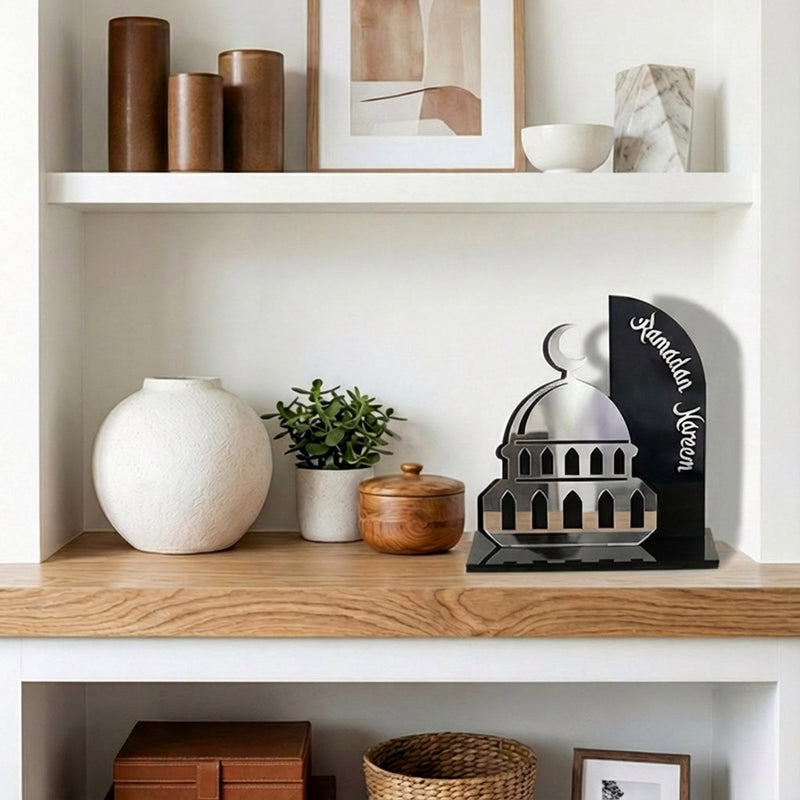 Decorative shelf with various items including a white vase, wooden box, and a metallic sculpture.